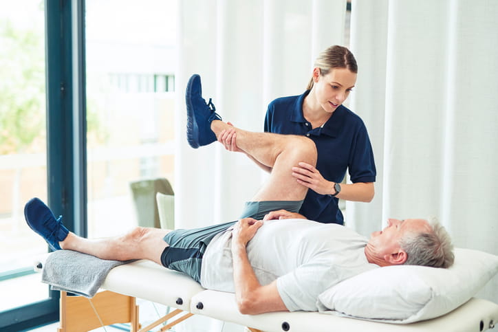 A physical therapist doing post-traumatic injury care on her patient. 