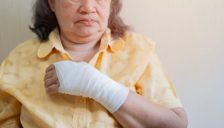 A senior woman with her wrist and hand bandaged after an accident. 