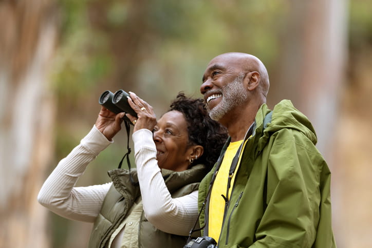 Top Summer Outdoor Activities For Seniors In Bountiful 1 Two seniors are smiling as they birdwatch.