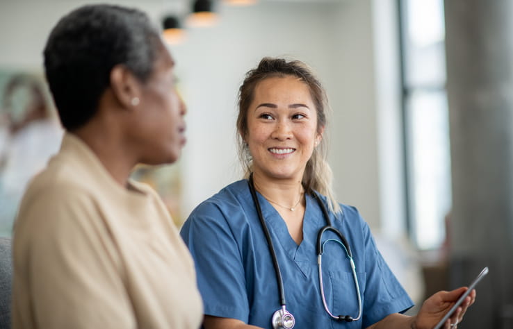 A nurse speaks with a patient at a skilled nursing facility. 