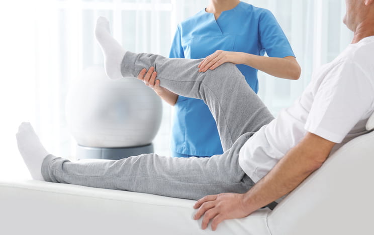 A physical therapist works with a patient regarding arthritis in his knee.
