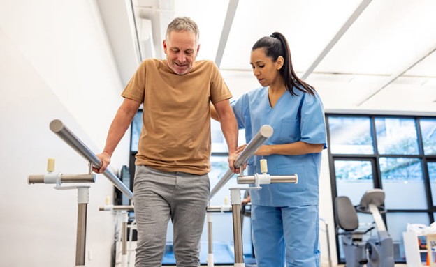 A physical therapist helps a patient with fall prevention.