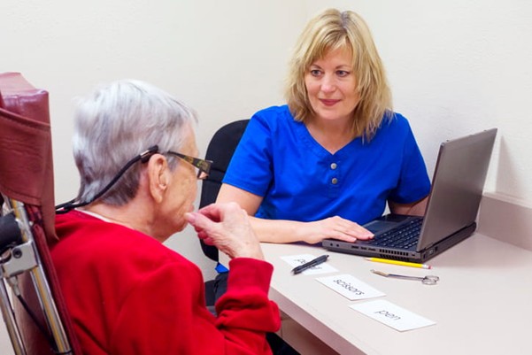 A speech therapist works with an elderly patient.