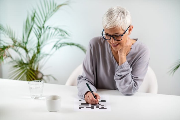 A senior working on a crossword puzzle for a memory game.
