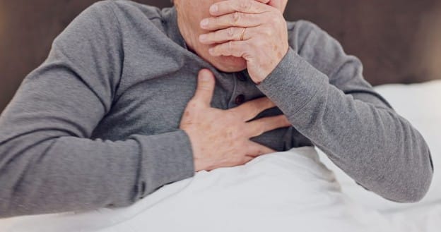 Pneumonia in the Elderly: Symptoms, Causes, Treatment & Prevention 2 An elderly man covers his mouth and holds his chest as he coughs from pneumonia.