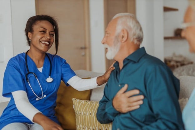 How To Handle Guilt When Moving A Parent Into Skilled Nursing 2 A nurse smiles at one of her elderly patients.