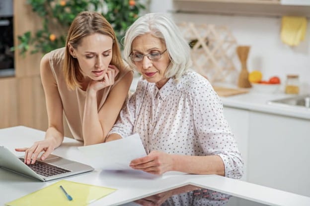 How To Organize Important Documents For An Aging Parent 2 A daughter reviews important documents with her elderly mother.